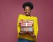 Happy young african american woman holding gift boxes smiling, enjoying many presents, celebrating xmas or birthday holiday. High quality photo